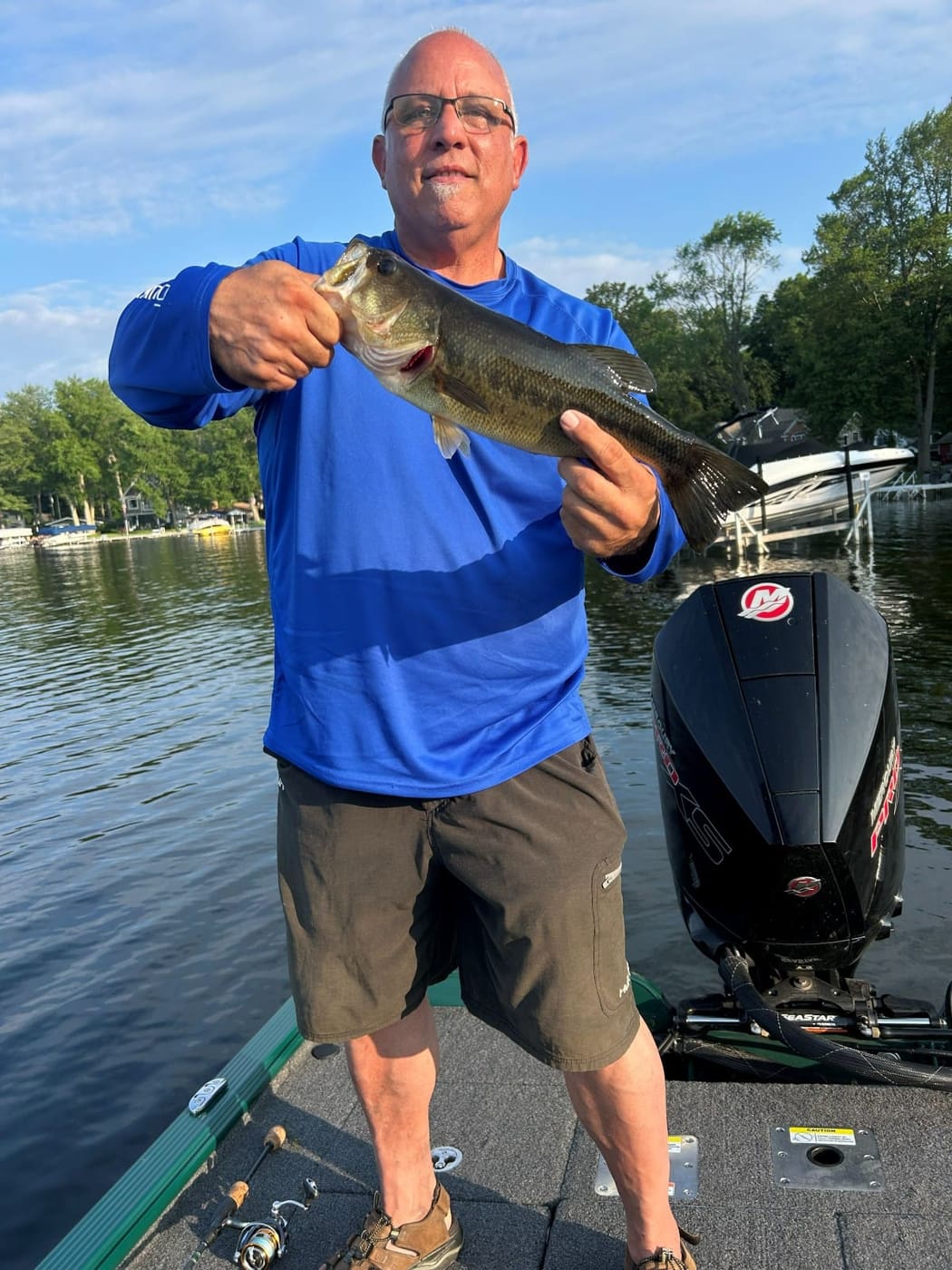 A client holding a largemouth bass on an inland lake