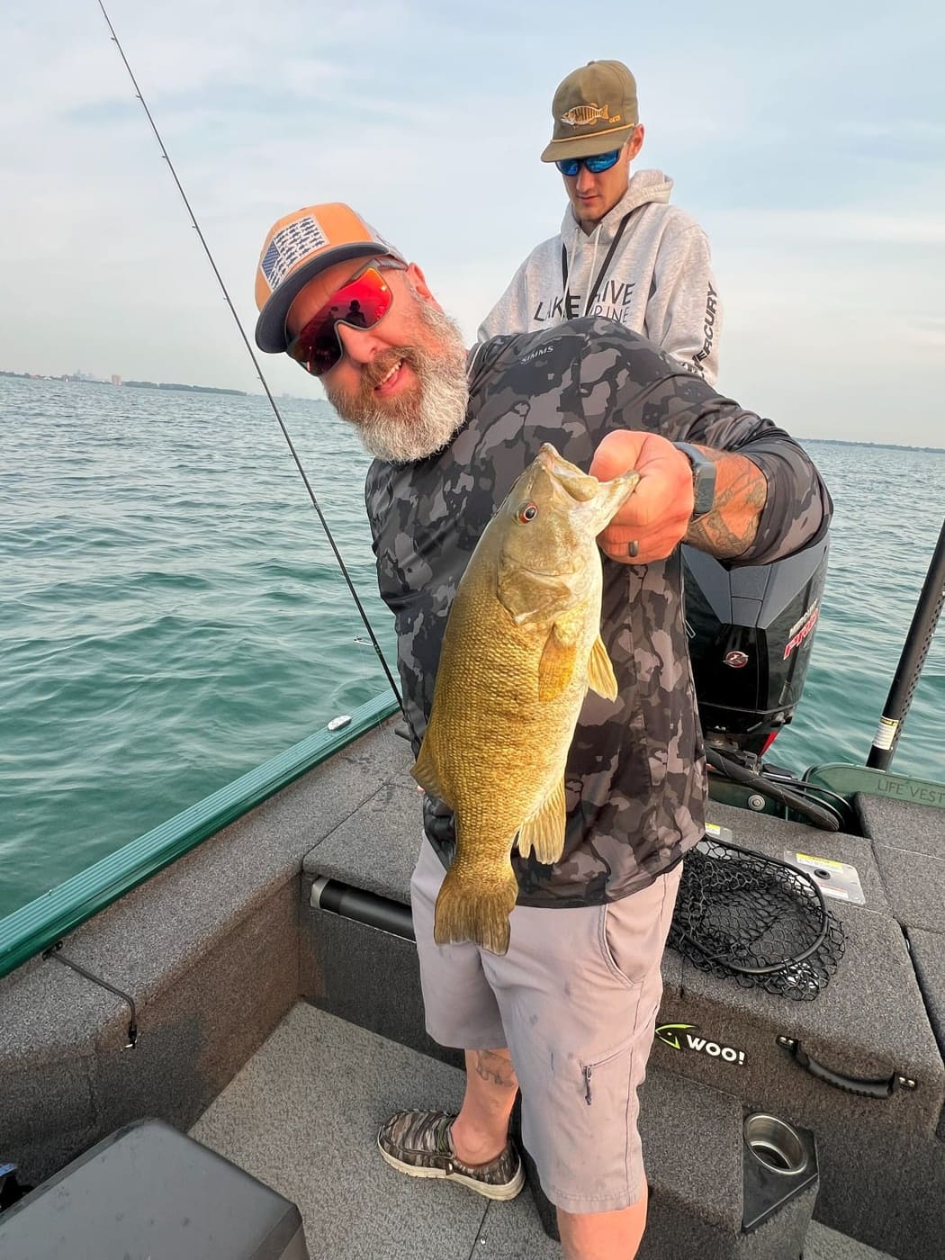 Clients with a smallmouth bass at golden hour