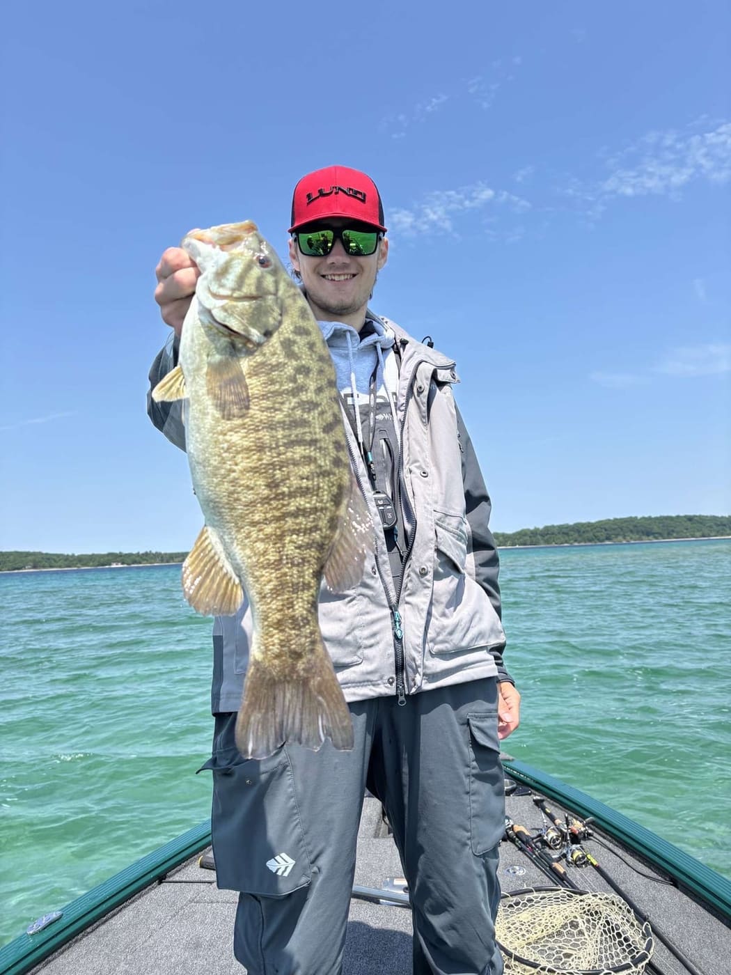 A client with a smallmouth bass on clear northern water
