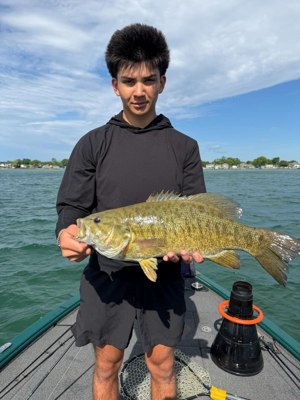 A young angler holding a thick smallmouth bass