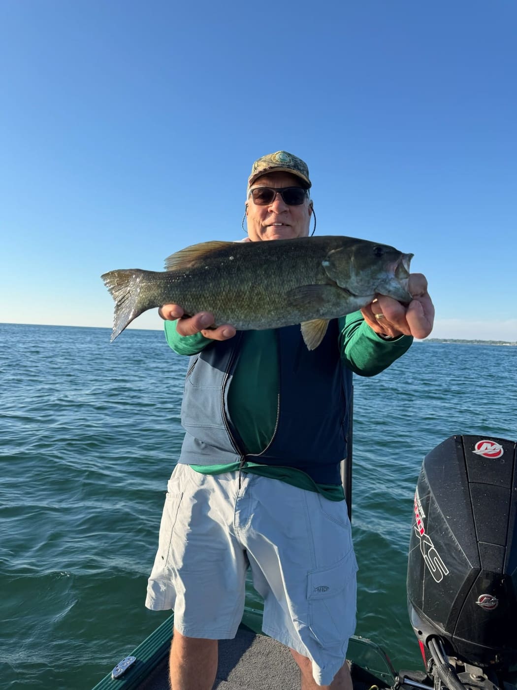 A client with a smallmouth bass caught aboard the Lund